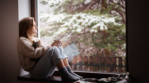 Woman and cat enjoying comfortable climate in home